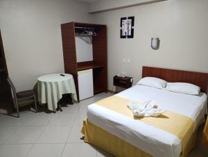 ein Schlafzimmer mit einem Bett, auf dem eine Blume liegt in der Unterkunft Hotel Alfredos in Pucallpa + 11 Fotos
