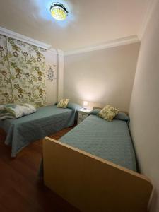 a small room with two beds and a lamp at Piso Moderno Puerto de la Cruz Villa Isabel in Puerto de la Cruz