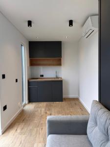 a living room with a couch and a kitchen at Tinyhome Murtal -SlowCamping in Fohnsdorf