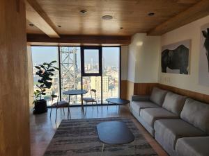 a living room with a couch and a large window at Steps to Historic C and Reforma in Mexico City +6 photos