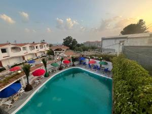 an overhead view of a swimming pool with umbrellas and chairs at Résidence île des Pisans Nezla in Bejaïa