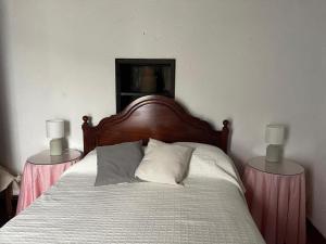 a bedroom with a bed with two lamps on tables at Quinta do Monte Santo in Vila do Porto