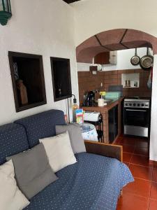 a living room with a blue couch and a kitchen at Quinta do Monte Santo in Vila do Porto +36 photos