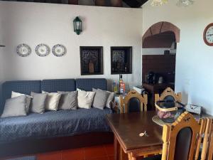 a living room with a blue couch and a table at Quinta do Monte Santo in Vila do Porto