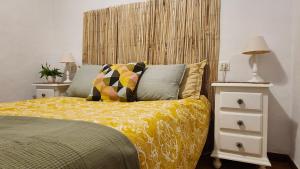 a bedroom with a bed with a yellow comforter at Casa del Delfin in Iznájar