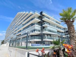 a building on the beach with a palm tree at Perla Home, 1ªLínea, Magic World in El Borseral