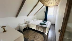 a small bedroom with a bed and a window at Cabana cu ciubăr din Larguta in Şinca Nouă