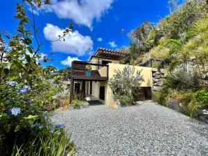 ein Haus auf einem Hügel mit einer Kiesauffahrt in der Unterkunft Casa Carolina - Modern Villa with Private Pool in Coral Bay