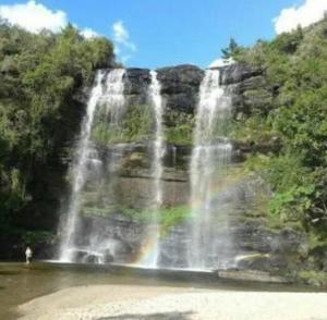 a waterfall with a rainbow in the water at Cachoeira da Mariquinha Ecoturismo in Ponta Grossa