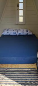 a bed with a blue mattress in a room with a window at Cachoeira da Mariquinha Ecoturismo in Ponta Grossa