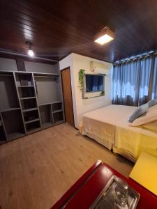 a large room with two beds and a window at Flamboyant Residence in Fernando de Noronha