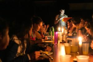 a group of people sitting around a table with candles at Ecotone Manu Learning Center, All-Inclusive in Pillcopata
