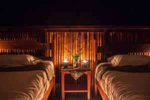 a bedroom with two beds and two candles on a table at Ecotone Manu Learning Center, All-Inclusive in Pillcopata
