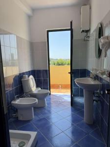 a bathroom with two toilets and two sinks at Hotel De Liege in Velipojë +28 photos