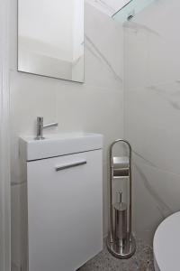 a white bathroom with a sink and a toilet at Apartments with parking space Icici, Opatija - 14155 in Ičići