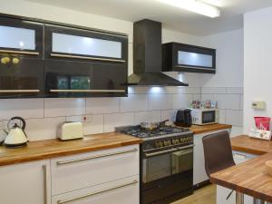 a kitchen with a stove top oven next to a table at Belmont in Longton +8 photos