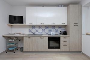 a kitchen with white cabinets and a counter top at Apartments with parking space Icici, Opatija - 14155 in Ičići +21 photos