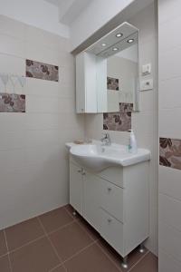 a white bathroom with a sink and a mirror at Apartments with parking space Icici, Opatija - 14155 in Ičići