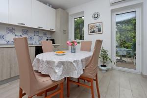 a dining room with a table and chairs with flowers on it at Apartments with parking space Icici, Opatija - 14155 in Ičići