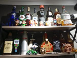 a shelf filled with lots of bottles of alcohol at Hotel Pousada Sol Nascente Mafraa in Mafra +14 photos