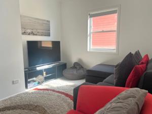 a living room with a couch and a flat screen tv at Avalon 3 in Yamba