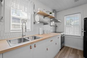 een keuken met witte kasten en een spoelbak bij Beachside Cottage - Pet Friendly in Oak Island +35 foto's