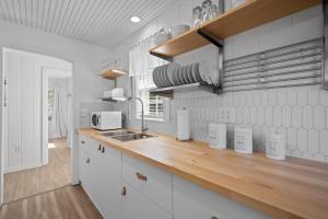een keuken met witte kasten en een houten aanrechtblad bij Beachside Cottage - Pet Friendly in Oak Island