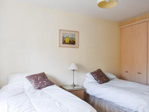 a bedroom with two beds and a lamp on a table at Lime Court - Cottages in Leatherhead