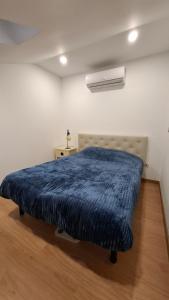 a bedroom with a blue blanket on a bed at Apartamento T1 Arcos de Valdevez - centro da vila in Arcos de Valdevez