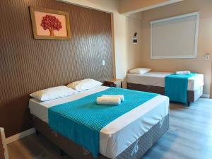 a hotel room with two beds with blue sheets at Do Parque Pousada Comfort in Penha