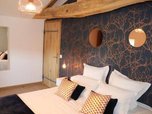 una camera da letto con un letto con cuscini bianchi di Gîte de charme avec piscine couverte, idéal pour 10 pers., PMR, proche Puy du Fou, grand jardin, loisirs - FR-1-426-428 a Les Herbiers