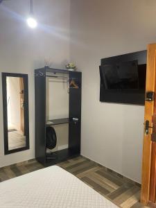 a room with a bed and a mirror and a closet at Chalés Praias do Sana in Macaé +32 photos