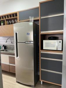 un réfrigérateur dans une cuisine à côté d'un four micro-ondes dans l'établissement Apartamento em Vila Velha, à Vila Velha