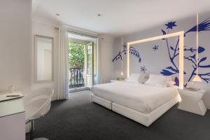 ein Schlafzimmer mit einem weißen Bett und blauen Wänden in der Unterkunft Room Mate Mario, Madrid in Madrid