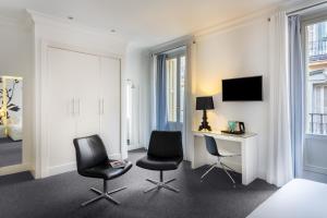 Habitación de hotel con 2 sillas y escritorio en Room Mate Mario, en Madrid