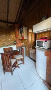 a kitchen with a microwave and a table and chairs at Casa na orla in Porto Seguro