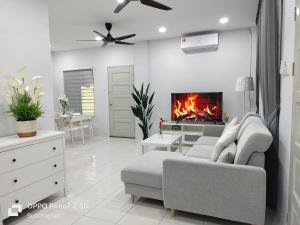 a living room with a couch and a fireplace at Summerset Guesthouse in Kuching