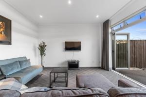 Una sala de estar con un sofá y un televisor. en D-Street Retreat - Hamilton, en Hamilton