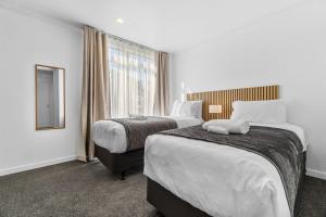 Una habitación de hotel con dos camas y un espejo. en D-Street Retreat - Hamilton, en Hamilton
