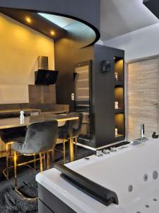 Love Room Le Jardin D'Éden في لاموت سيرفولكس: حمام مع طاولة وحوض استحمام