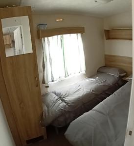 a small bedroom with a bed and a window at The retreat in Selsey