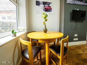 stół jadalny z 2 krzesłami i wazon z kwiatami w obiekcie Bucknall Lodge Hanley Family Room 3 w mieście Stoke-on-Trent +14 zdjęć