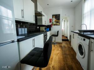kuchnia z białymi szafkami i pralką i suszarką w obiekcie Bucknall Lodge Hanley Family Room 3 w mieście Stoke-on-Trent