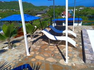 a patio with two chairs and an umbrella at Liz&Mar Glamping in Tubará