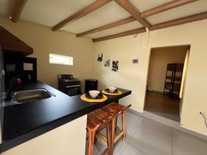 a kitchen with a black counter and a sink at Inn Home Aparta-Suite in Salento