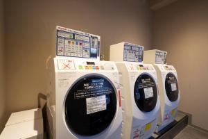 a row of white washing machines in a room at Hotel Oriental Express Fukuoka Nakasu Kawabata in Fukuoka