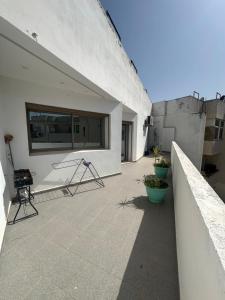 Un balcón de un edificio blanco con algunas plantas. en Central Kenitra Loft, en Kenitra