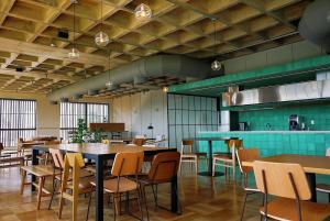 a restaurant with tables and chairs and a kitchen at FLAT NOVO e ACONCHEGANTE in Ribeirão Preto
