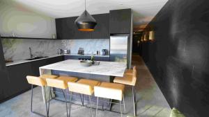 a kitchen with a white counter and some brown chairs at Konayuki Apartment 7 in Falls Creek