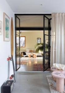 オスロにあるCasa by Bjørkheim, Modern Villa in Osloのサーフボードが置かれたガラスの引き戸のあるリビングルーム